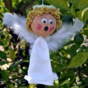 Lace Frill Sock Christmas Angel - finished angel with wings added hanging from a tree branch