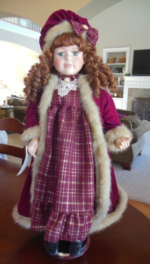 Value of a Collectible Memories Porcelain Doll - red haired doll wearing a red coat with fur trim and a plaid dress