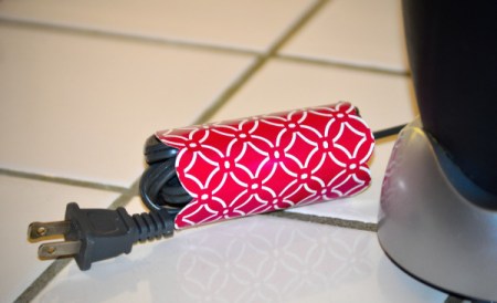 A piece of recycled cardboard from a tissue box, wrapped around an appliance cord.