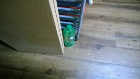A bottle of soda to hold a refrigerator door open.
