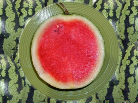 A small seedless watermelon, cut in half.