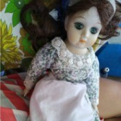 Identifying a Porcelain Doll - doll wearing a floral dress and apron