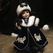 Identifying a Porcelain Doll - dark haired doll wearing a fur trimmed coat and fur hat