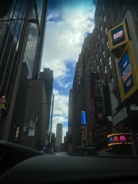 The sun peeking through tall buildings in winter.