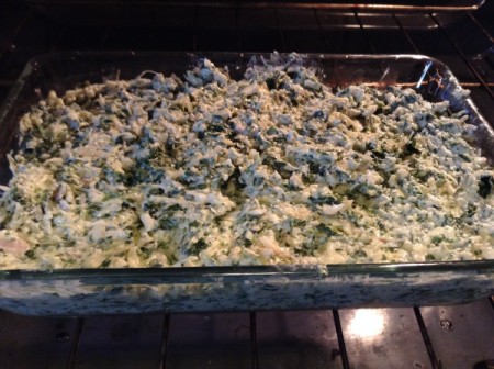 A baking dish filled with spinach artichoke dip.