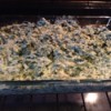 A baking dish filled with spinach artichoke dip.