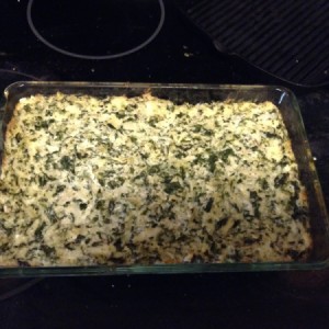 A baked dish of spinach artichoke dip.