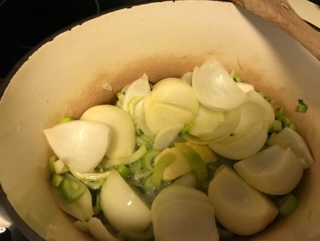 Cooked vegetables in a soup pot.