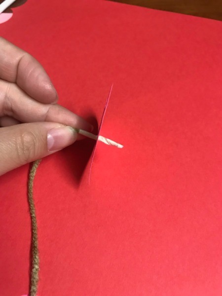 Heart Shaped Leis - pushing the yarn through a paper heart
