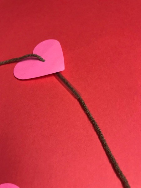 Heart Shaped Leis - yarn through hole in paper heart