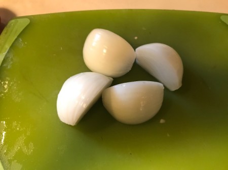An onion that has been cut in quarters.