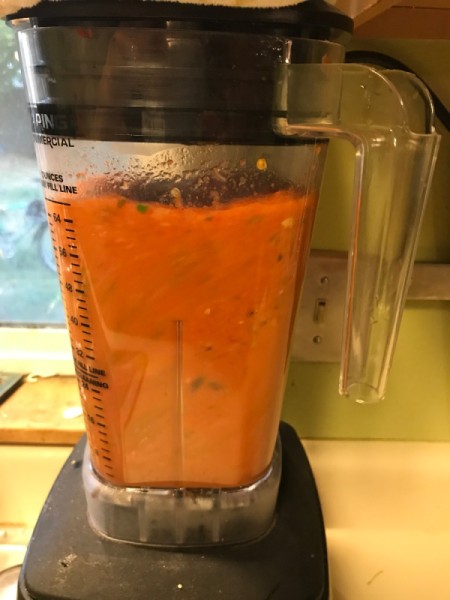 A blender filled with the ingredients for tomato soup.
