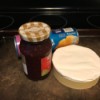 A jar of jam, a package of refrigerator crescent rolls and a package of brie.