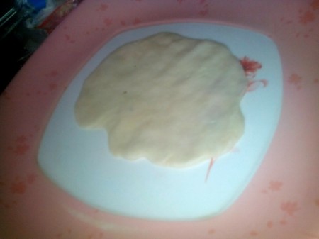 flattened ball of dough on plate