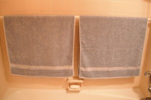 A shower rod in the bathtub used for hanging towels.