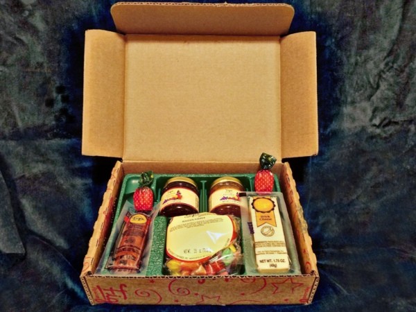 A Christmas box with a selection of summer sausage, cheese and jams.