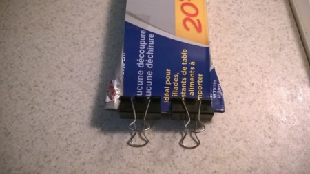 Binder clips being used to store a homemade cardboard knife case.