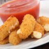 A plate of fried breaded cheese sticks with tomato sauce.