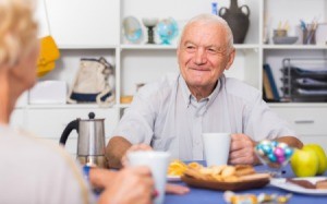 Elderly Man Sitting at Table Eating