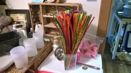 A clear plastic container being used to store craft pipe cleaners.