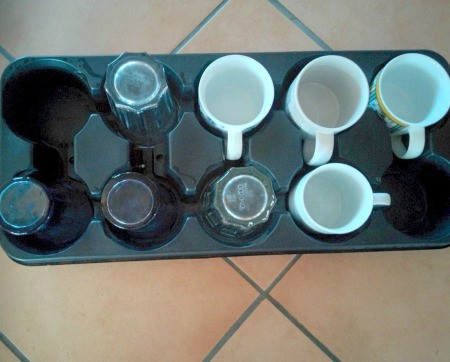 A plant tray being reused for coffee mugs and glassware.