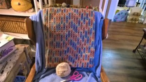 An afghan on a wooden chair.