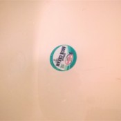 A drain temporarily plugged with a sour cream lid.