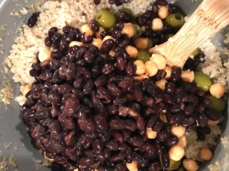 mixing Beans olives and Quinoa