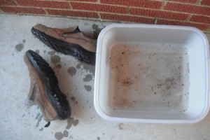 A pair of rubber soled shoes and a pan of water.
