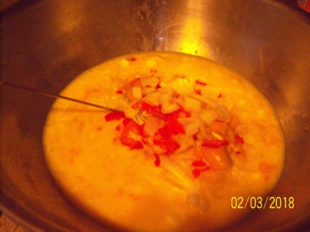 adding peppers and onions to egg