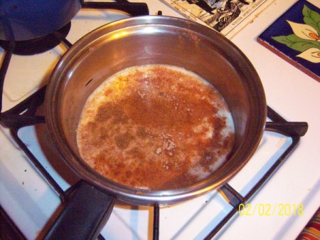 Oatmeal, milk and spices on burner