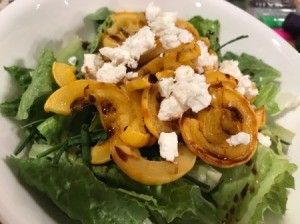 Roasted Delicata Squash on salad with cheese in bowl