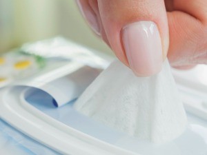 Woman Pulling up Baby Wipe from Container