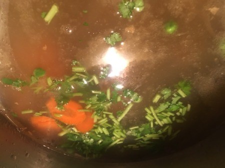 adding cilantro and carrot to broth