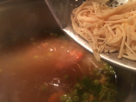 adding noodles to broth