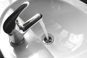 Closeup of porcelain sink with running water.