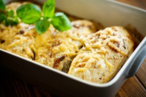 Baked chicken in a pan with melted cheese on top.