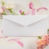 Envelope sitting on pink and white flowers.