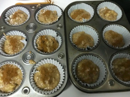 filled muffin cups sprinkled with cinnamon