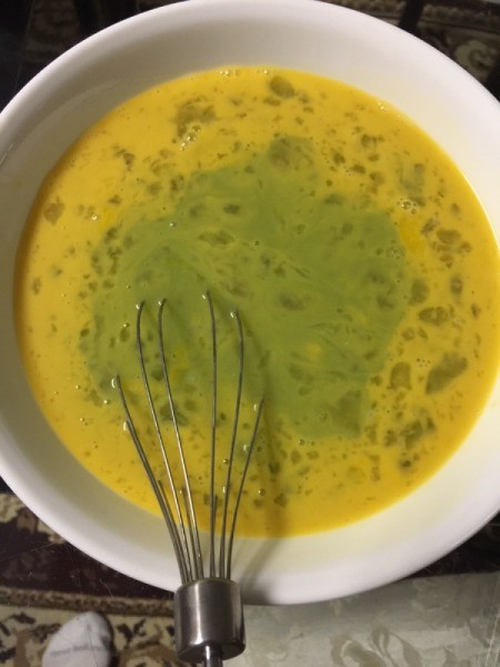 adding blended pandan leaves to eggs