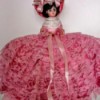 Identifying and Value of  a Vintage Doll - small plastic doll wearing a ruffled dark pink dress and hat