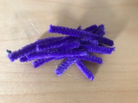 A pile of short purple pipe cleaners.