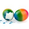 Two rainbow dyed easter eggs, one partly peeled.