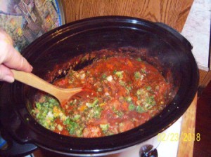 A crockpot of spaghetti sauce made with juiced vegetables.
