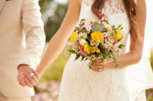 Close-up of bride and groom holding hands on their wedding day