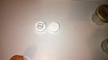 Two pill bottle lids.