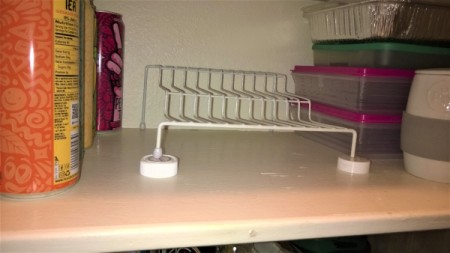 Using two pill bottle lids to support a wire shelf.
