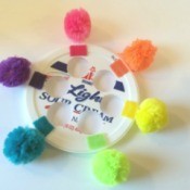 A recycled toddler toy with brightly colored pom poms.