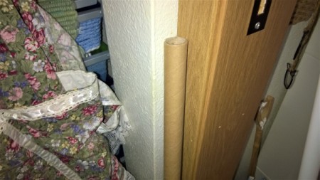 A cardboard tube being used to extend a broom handle.