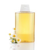 Bottle of shampoo with chamomile flowers.